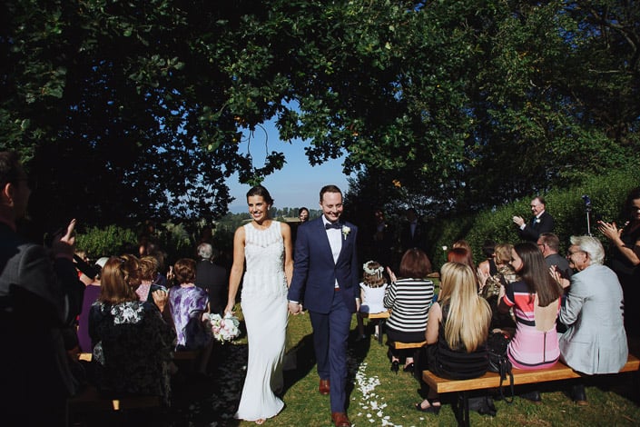 The newlyweds walk down the petal-strewn aisle at Paynes Rise.