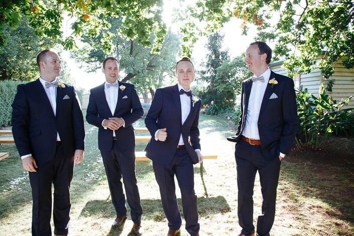 The four navy suits regroup on the shaded lawn