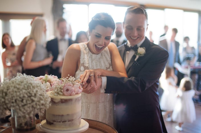 The knife sinks into the semi-naked cake to a delighted gasp