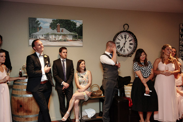 Guests listen to speeches beside wine barrels at Paynes Rise Wines.