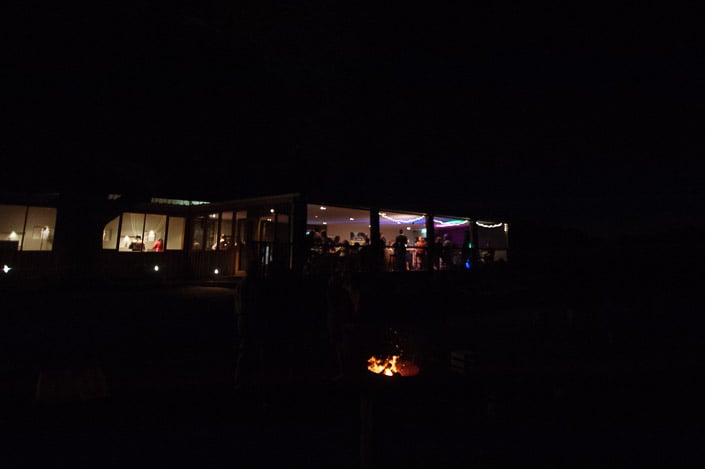 The Paynes Rise Wines cellar door glows behind a fire pit at night in the Yarra Valley.