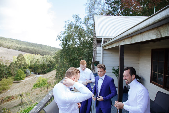 Groomsmen prepare on a timber cottage deck above the valley at Pennyroyal Otways Retreat