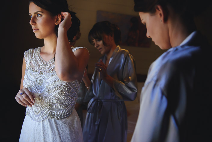 A hand sweeps back loose curls as the robes drift behind