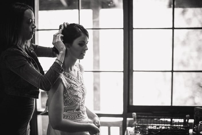 A stylist finishes the bride's plaited bun before the ceremony