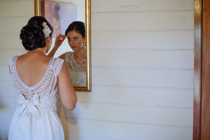 One last brow check in the gilt mirror, the satin bow at the bride's back.