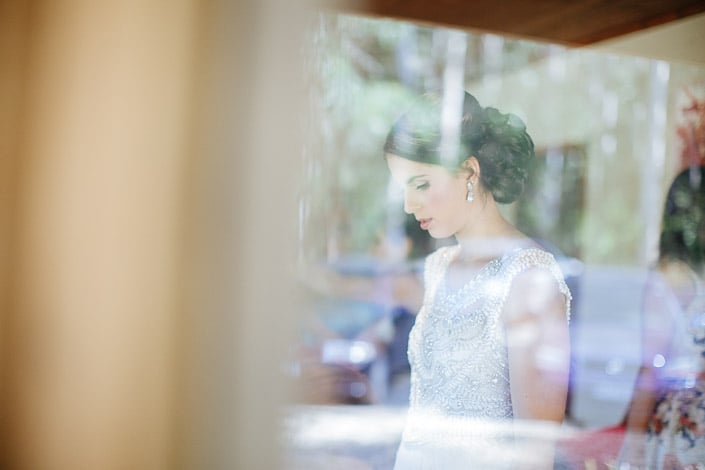 The bride lowers her head after her wedding updo is finished