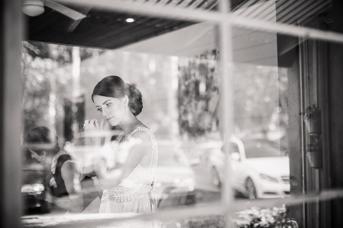 The bride checks her earring before the ceremony in black and white