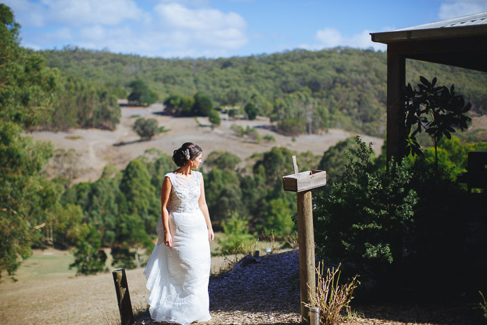 The bride looks over the Otways hills beside a timber post at Pennyroyal Otways Retreat
