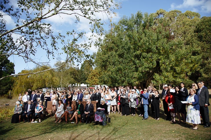 Wedding guests gather beneath birches near the lake at Pennyroyal Otways Retreat
