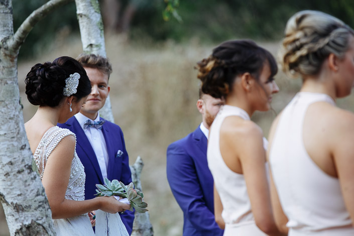 A look across the birch trunk as the vows begin