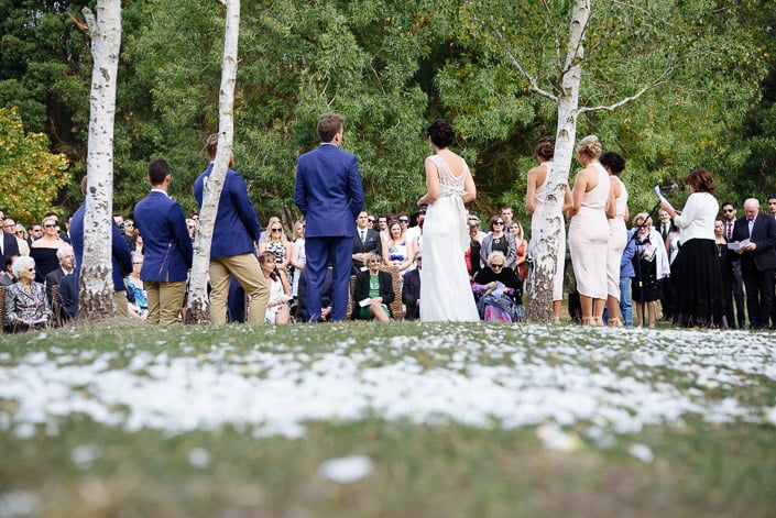 White petals cover the grass around the lakeside ceremony at Pennyroyal Otways Retreat