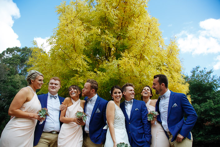 The wedding party laughs together beneath the golden canopy at Pennyroyal Retreat