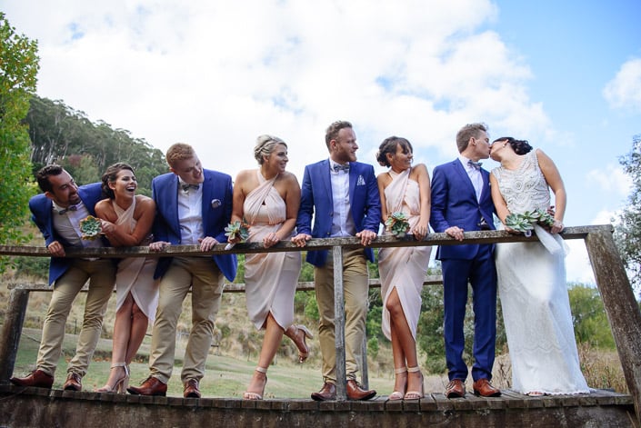 The wedding party leans along a timber footbridge at Pennyroyal Otways Retreat