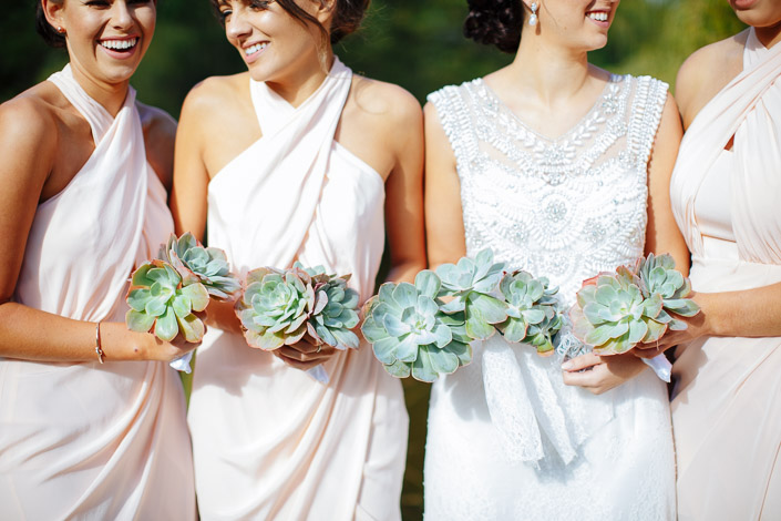 Four succulent posies against blush drape and beadwork