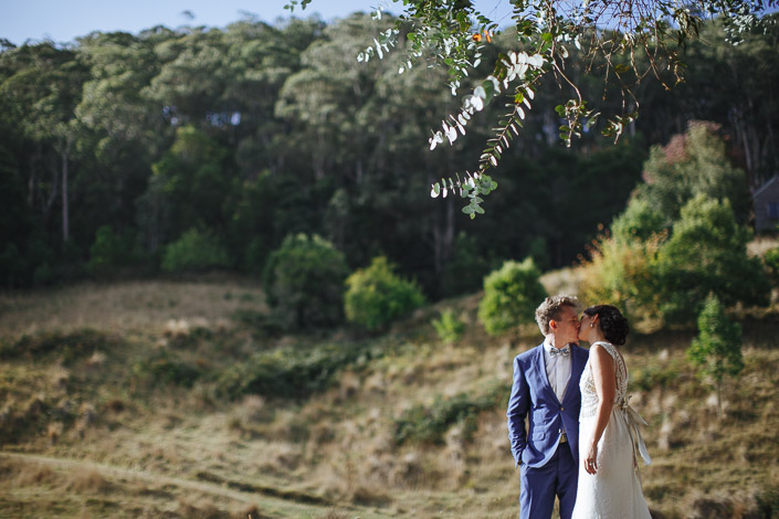 The groom kisses the bride's forehead during their portrait session