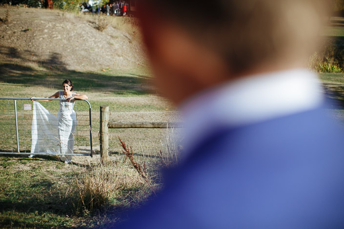 The bride laughs across the paddock from a Pennyroyal Retreat farm gate