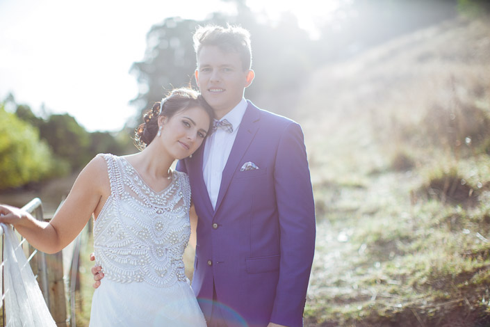 The bride rests her cheek against the groom's chest as they smile