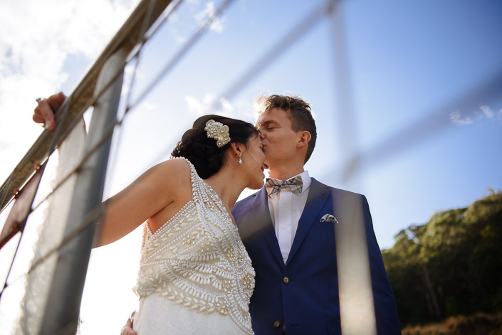 The couple kiss beside the timber footbridge at Pennyroyal Otways Retreat