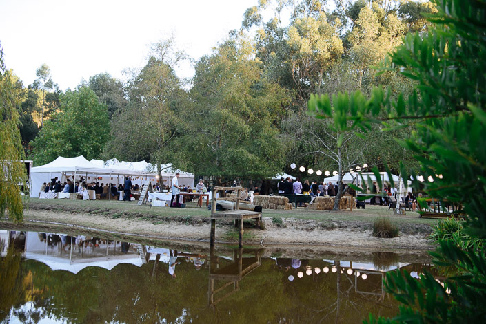 Lanterns and hay bales surround the lakeside reception at Pennyroyal Retreat