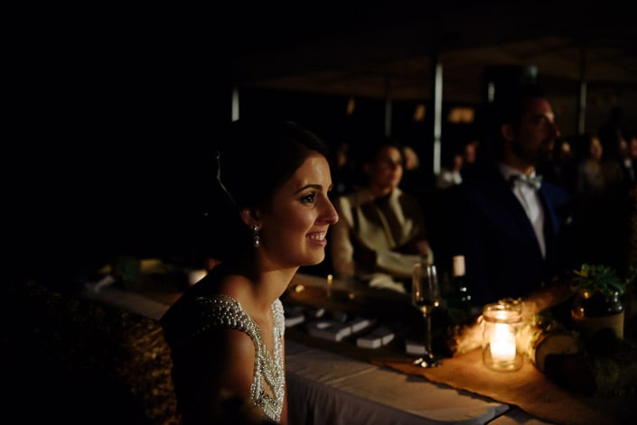 The bride smiles beside a candlelit reception table at Pennyroyal Otways Retreat