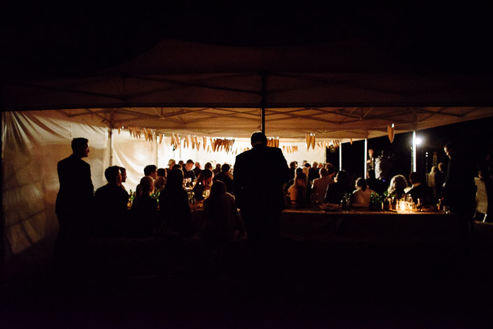 Guests gather inside the paper-bunting marquee at Pennyroyal Retreat after dark