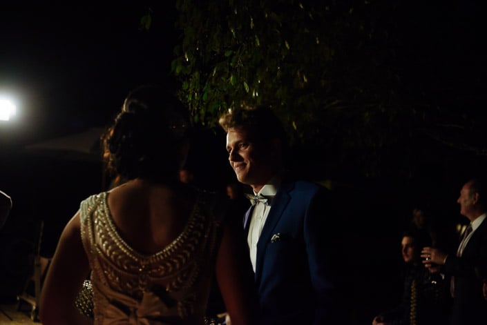 The groom's look across the night to the bride, her beaded back to camera.