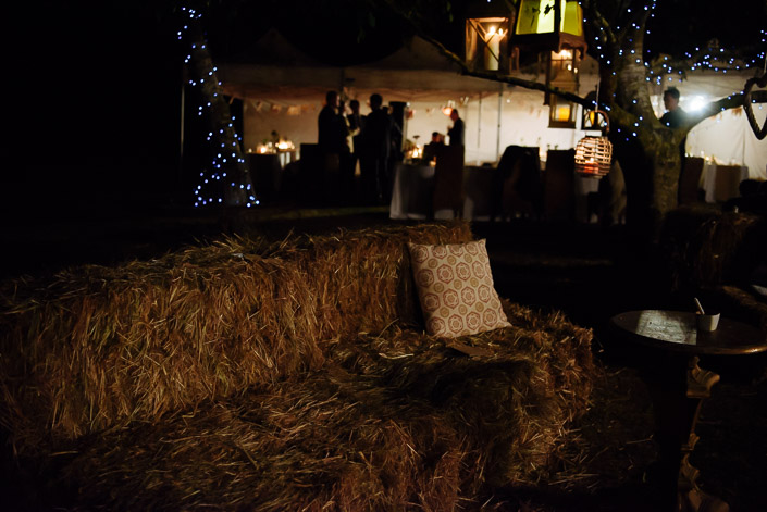 A hay-bale lounge faces the illuminated reception marquee at Pennyroyal Retreat