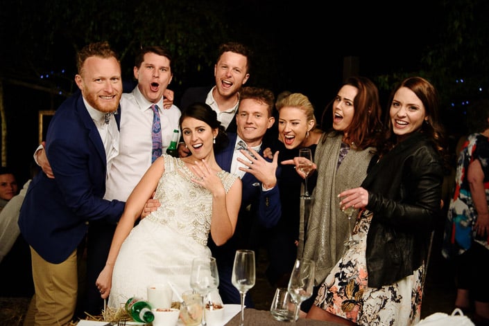 Rings flash at the camera in a crowd of open mouths