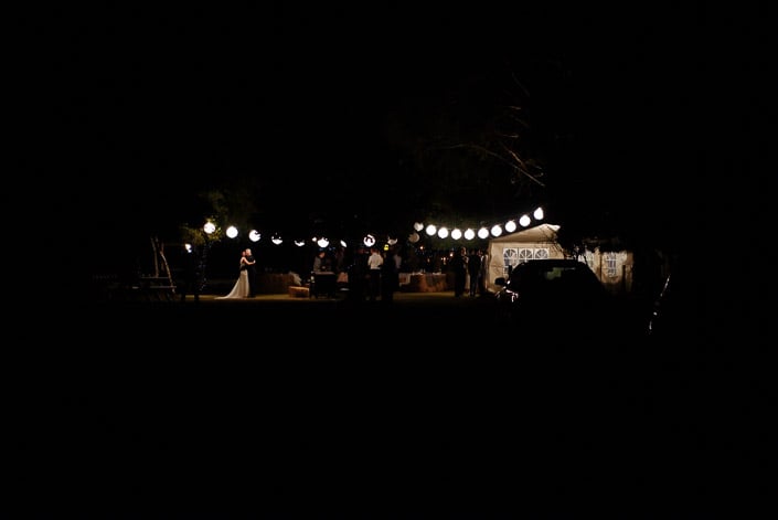 A distant view of the couple's night dance beneath lanterns at Pennyroyal Otways Retreat