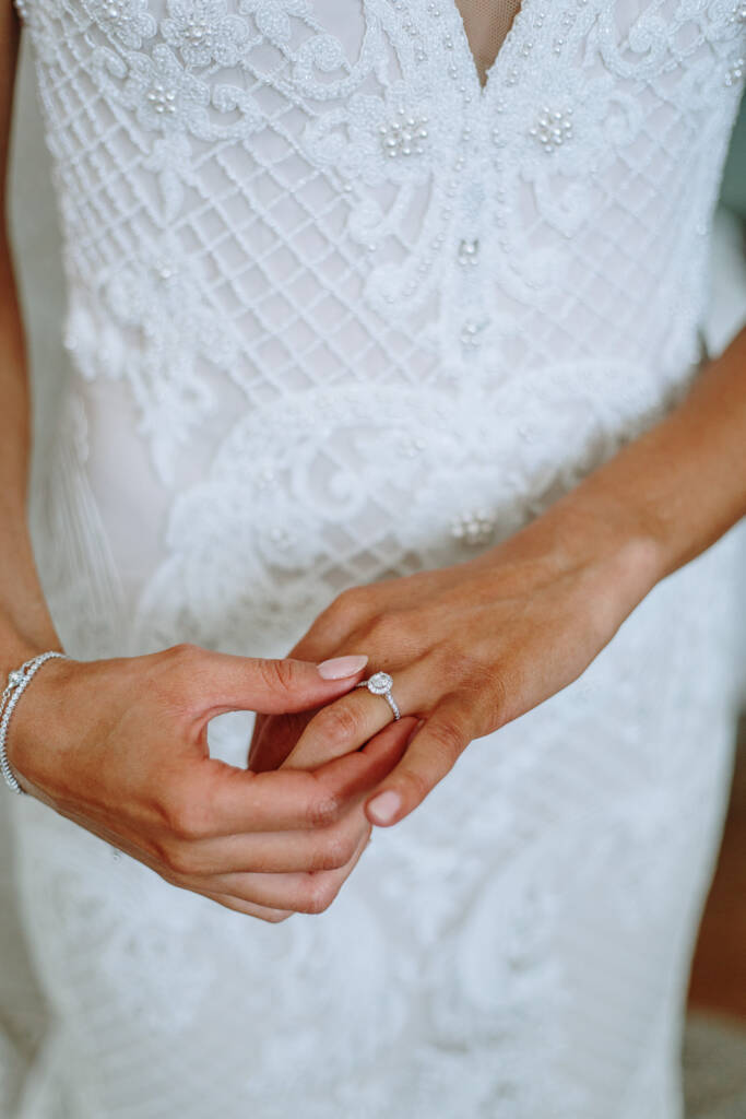 Close-up of Georgia touching her ring against the beaded lace of her gown.