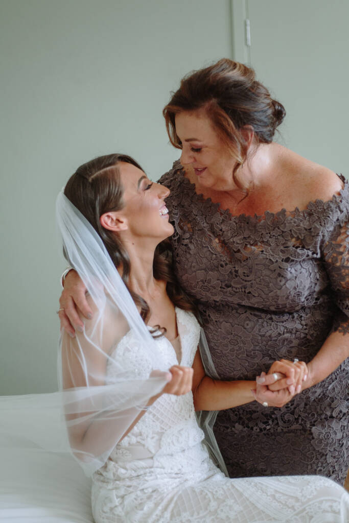 Georgia shares a smile and an embrace with a guest in grey lace.