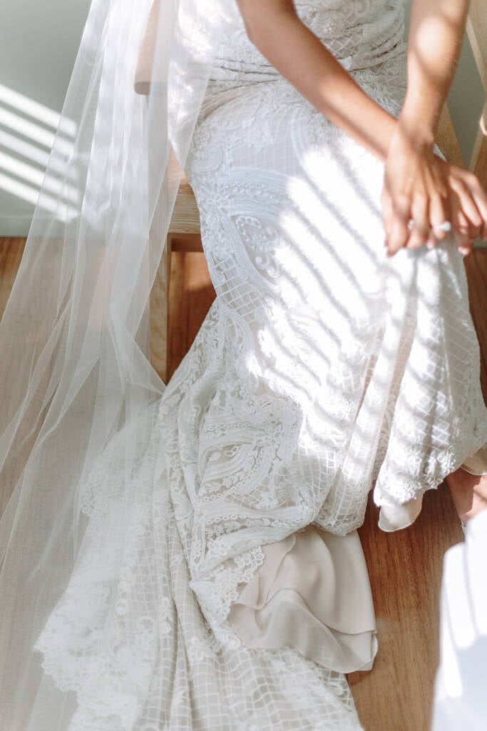 Bands of sunlight fall across Georgia's lace gown and veil at Prince Deck.