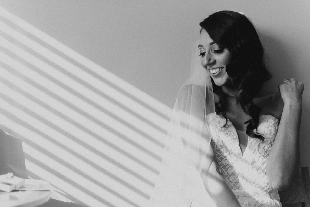 Black-and-white bridal portrait of Georgia with sunlight across her gown and veil at Prince Deck.