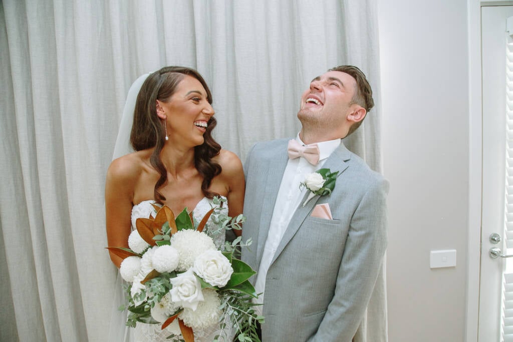Georgia laughs with a guest in a grey jacket.