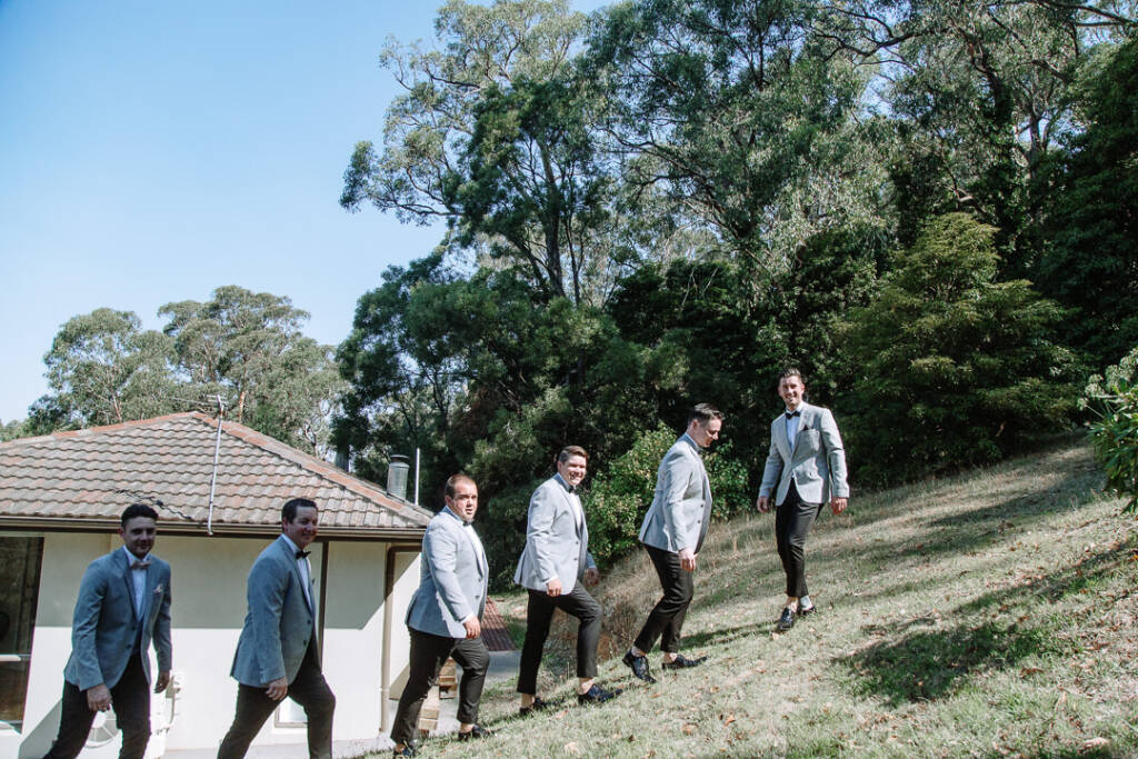 Michael and five attendants pose at different heights on the sloping lawn beside his home.