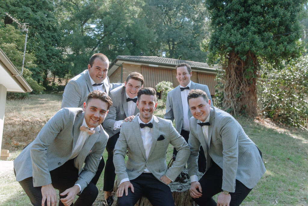 Michael and his attendants gather around a tree stump for a group portrait at home.