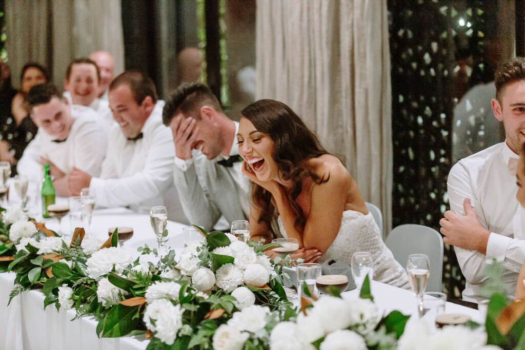 Georgia laughs over the reception table while Michael covers his face with his hand at Prince Deck.