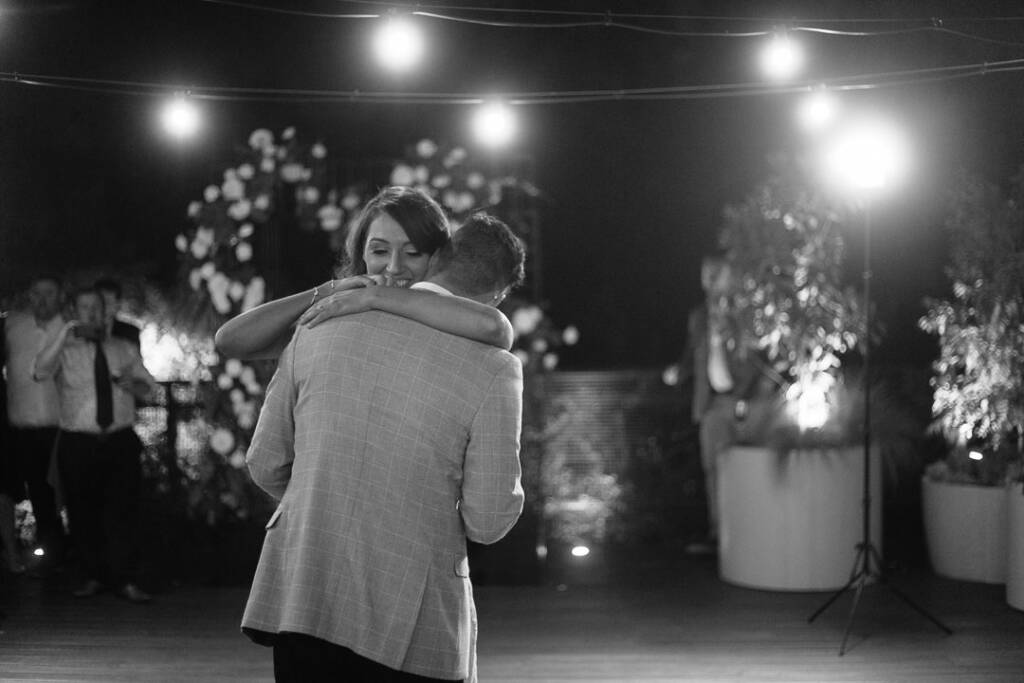 Black-and-white photo of Georgia and Michael dancing beneath festoon lights at The Prince Deck.