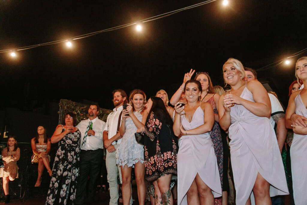 Bridesmaids and guests watch the dancing with drinks in hand at Prince Deck.