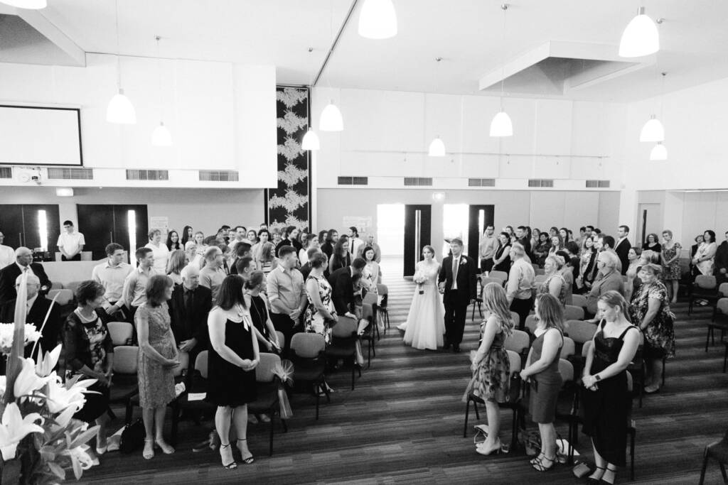 From above, Sue walks the aisle on his arm through the hall at Syndal Baptist Church.