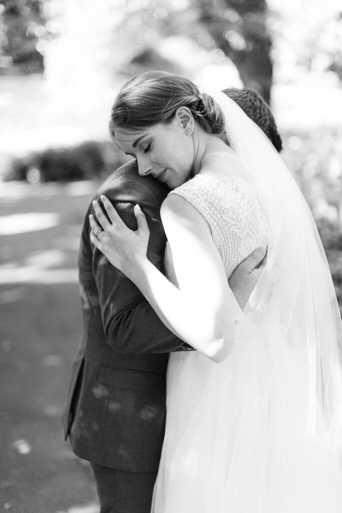 Sue rests her cheek on Chris's shoulder during a Canterbury Gardens wedding portrait.