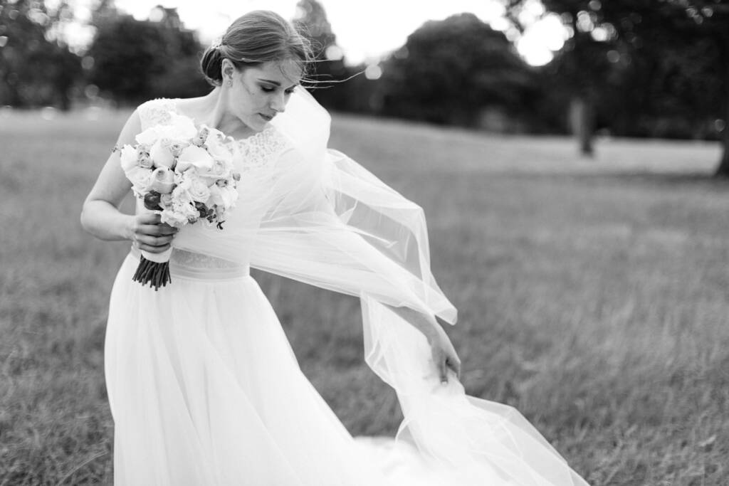Sue holds her bouquet as her veil catches the breeze on a Riversdale Golf Club fairway.