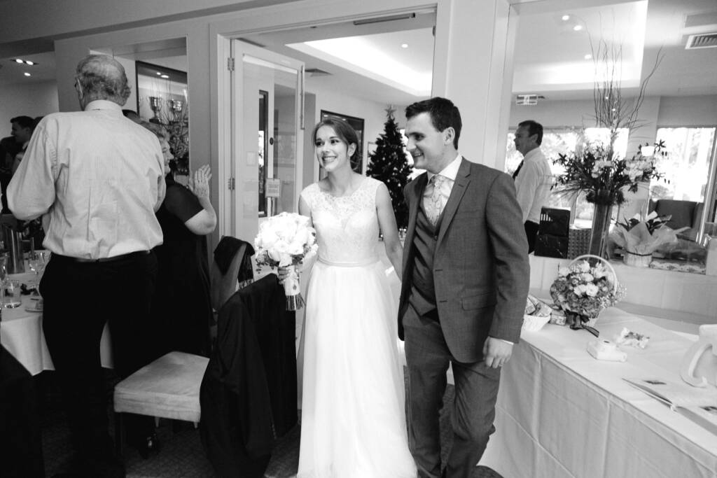Sue and Chris enter the Riversdale Golf Club reception hand in hand as guests applaud.