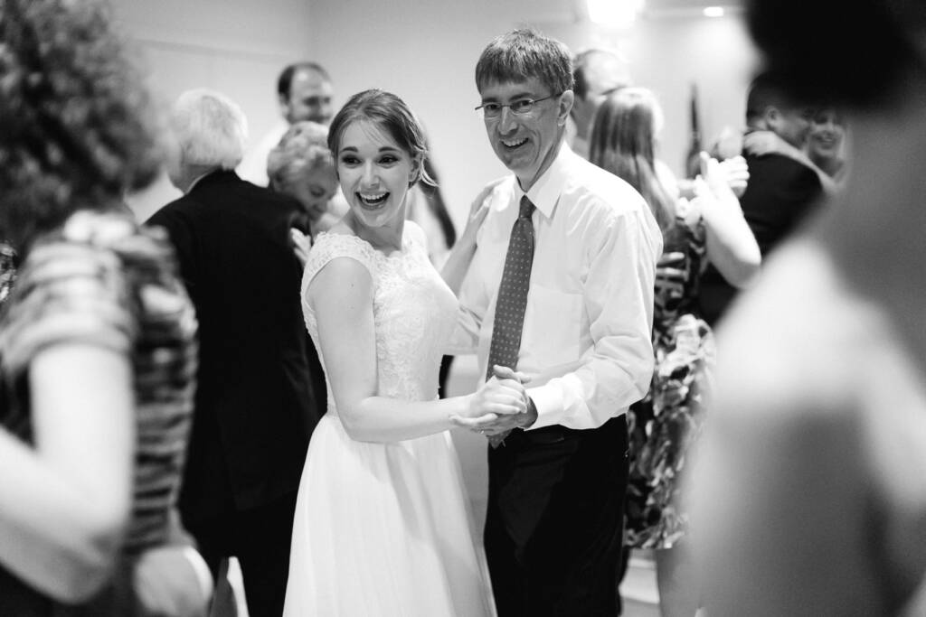 Sue smiles while dancing with a man in glasses at the Riversdale Golf Club reception.
