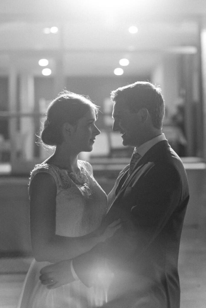 Sue and Chris face each other in backlight on the Riversdale Golf Club dance floor.