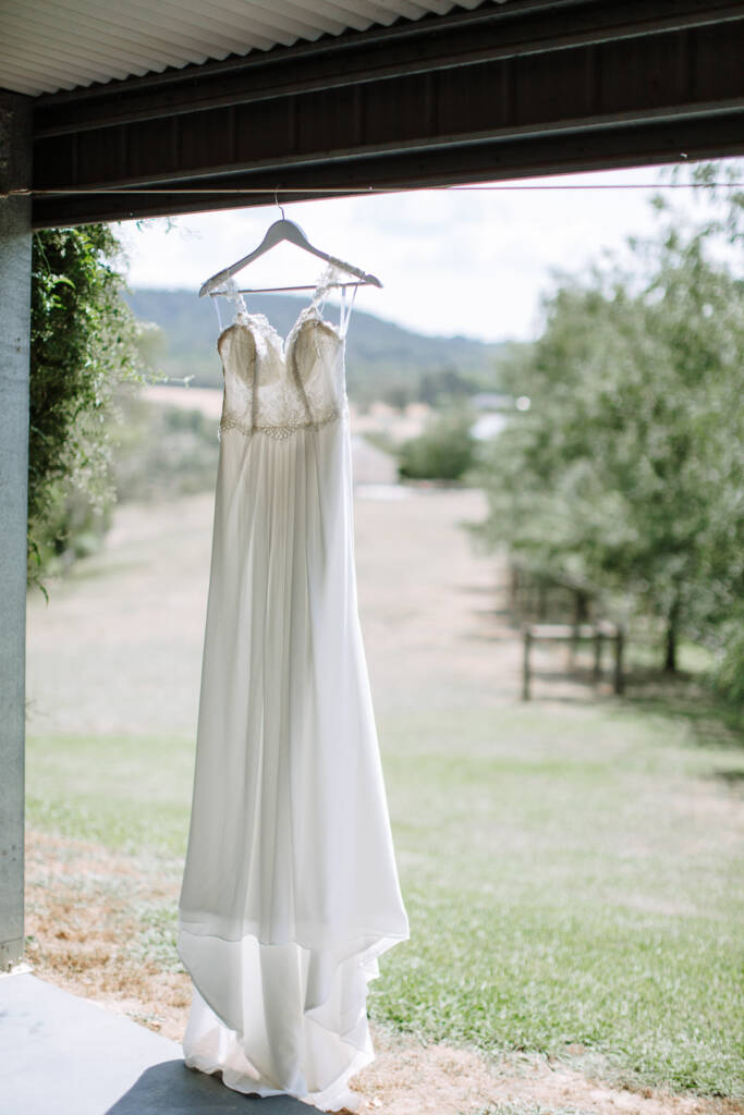 Kate's lace-bodice gown hangs beneath the verandah roof at her Chum Creek Airbnb, overlooking the lawn.
