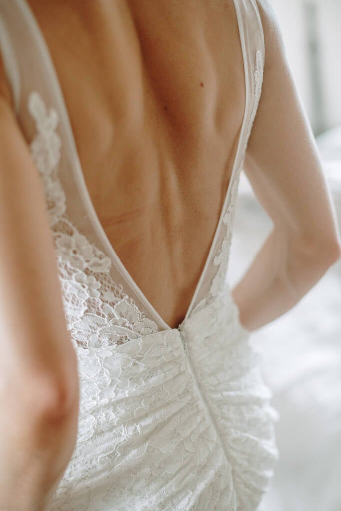 Close-up of the deep V-back and ruched lace on Ashlee's gown.