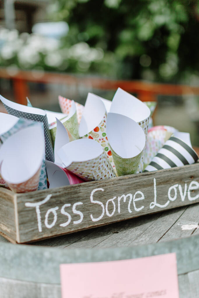 Patterned confetti cones sit in a timber tray marked Toss Some Love at Riverstone Estate.