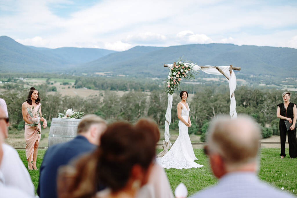 Ashlee waits beneath the draped timber arbour at Riverstone Estate.