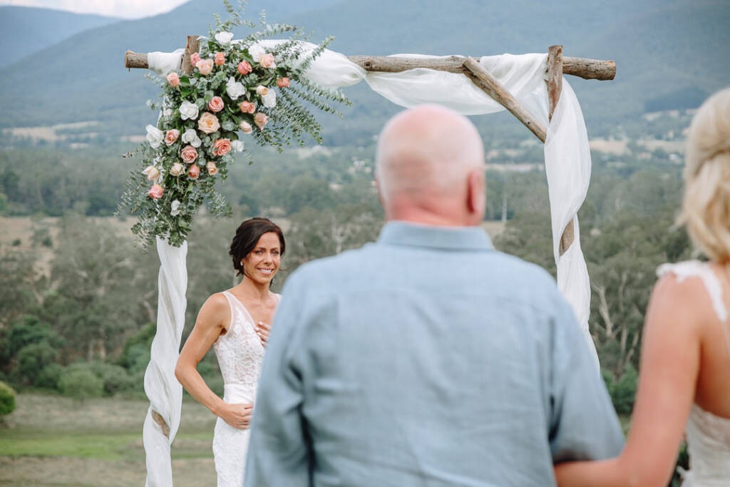 Ashlee smiles with a hand at her chest as Kate approaches the arbour at Riverstone Estate.